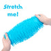 A bright blue textured, fringed squeeze toy being stretched by two hands against a white background, with the text 'Stretch me!' in blue in the upper left corner.