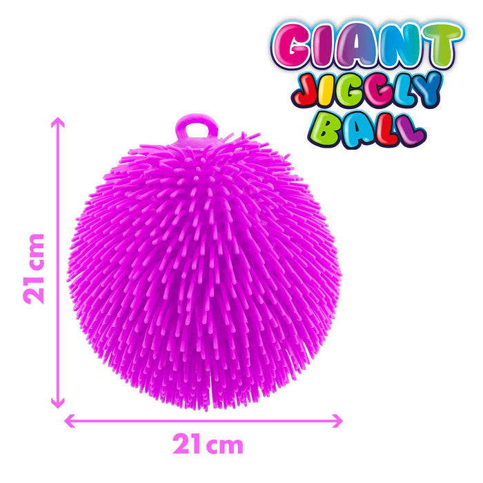 A bright pink spiky jiggly ball toy with a small hanging loop at the top, shown on a white background with pink dimension arrows and text indicating 21 cm width and height. A colorful 'GIANT JIGGLY BALL' logo appears in the top right.