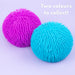 Two textured, spiky squeeze balls in bright magenta pink and cyan blue on a light lavender background, with the text 'Two colours to collect!' in the top right corner.
