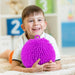 Child holding a purple textured ball in a classroom setting