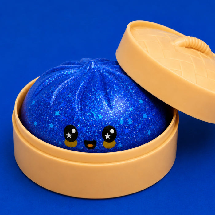 A blue glittery dumpling-shaped container with a cute cartoon face peeking out from inside, shown with a beige lid resting beside it on a solid blue background.